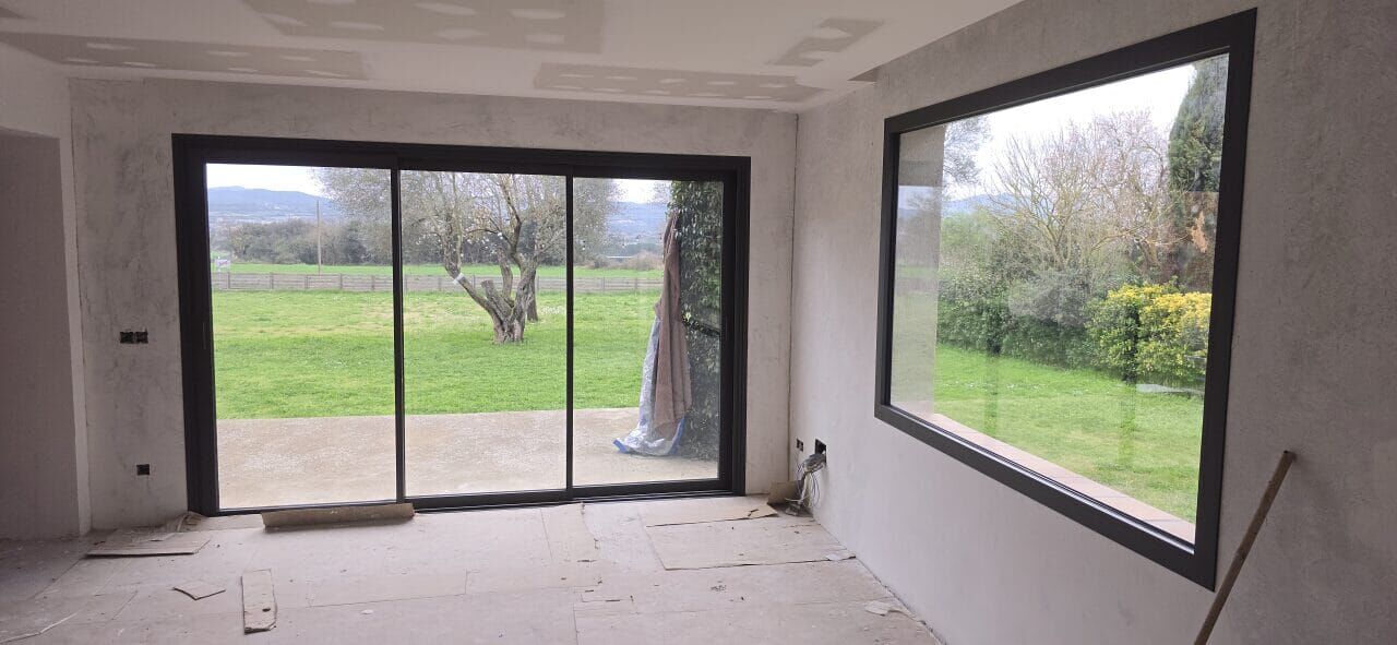 Gran corredera de aluminio negro con vistas a un jardín